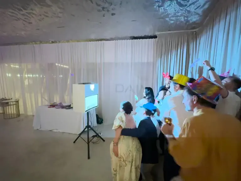 Invitați cu pălării și accesorii, pozând la cabina foto