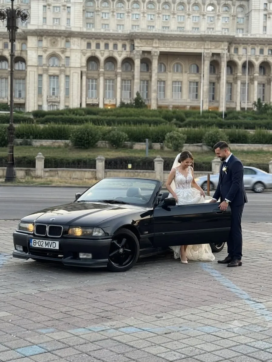 Miri lângă BMW-ul cabrio negru, în fața Palatului Parlamentului
